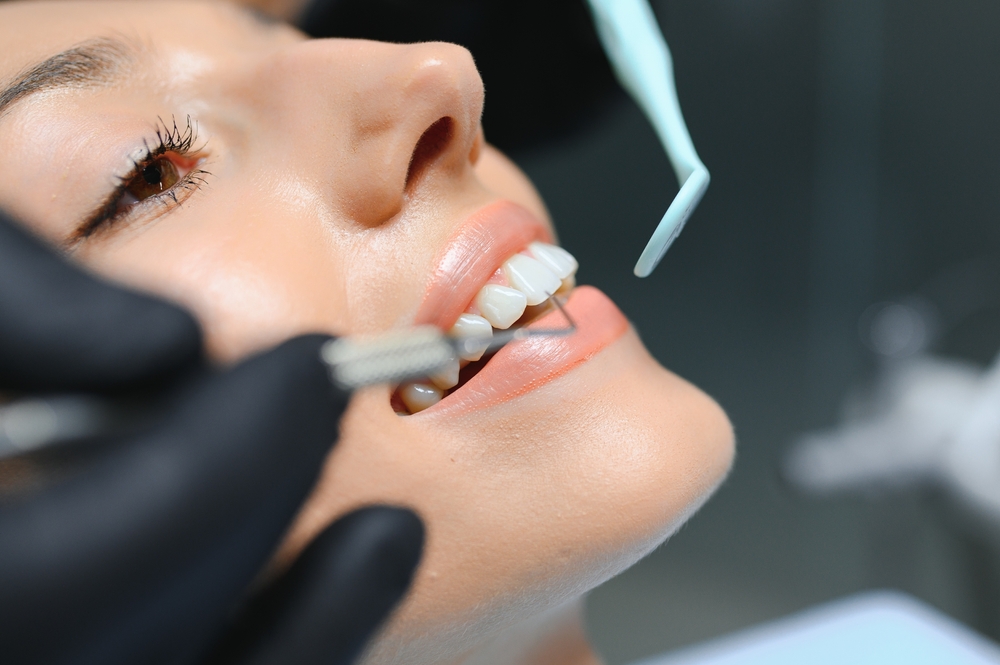 A close-up of a dentist examining a patient's teeth with dental instruments - Dentist University Place WA A close-up of a dentist examining a patient's teeth with dental instruments - Dentist University Place WA