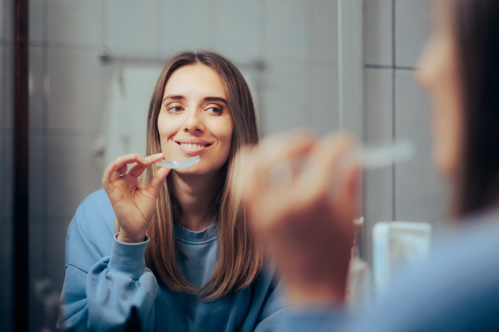Woman Taking off Her Clear Retainer - Cosmetic Dentistry